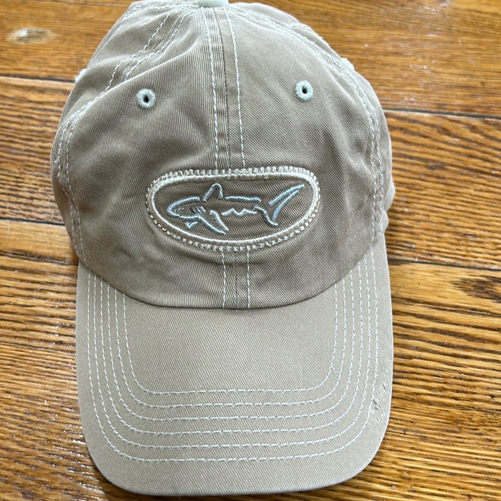 Greg Norman brand tan cap. Velcro to adjust size in back. Good condition. OS